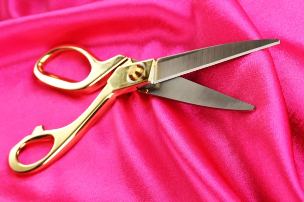 Metal scissors on pink fabric — Stock Photo, Image