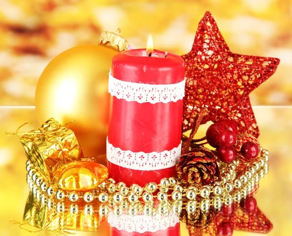 Красная свеча с рождественским декором на ярком фоне — стоковое фото