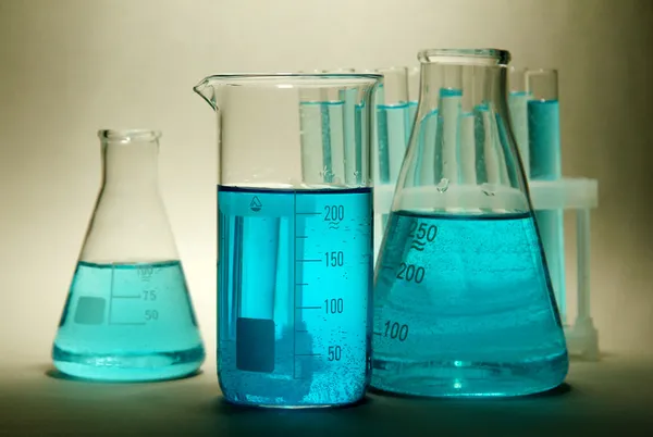 Test-tubes with blue liquid on grey background — Stock Photo, Image