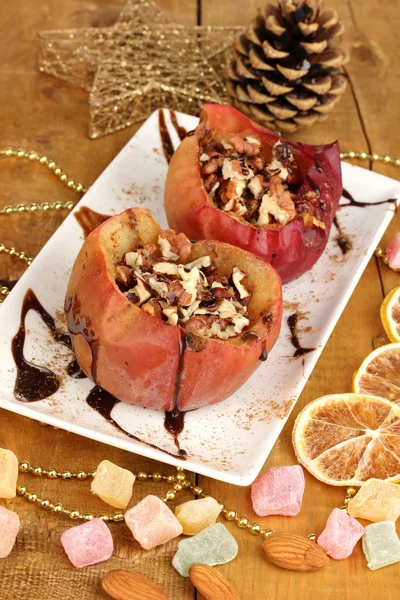 Baked apples on plate on wooden table — Stock Photo, Image