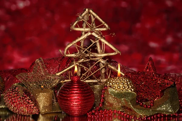 Composición navideña con velas y decoraciones en colores rojo y dorado sobre fondo brillante —  Fotos de Stock