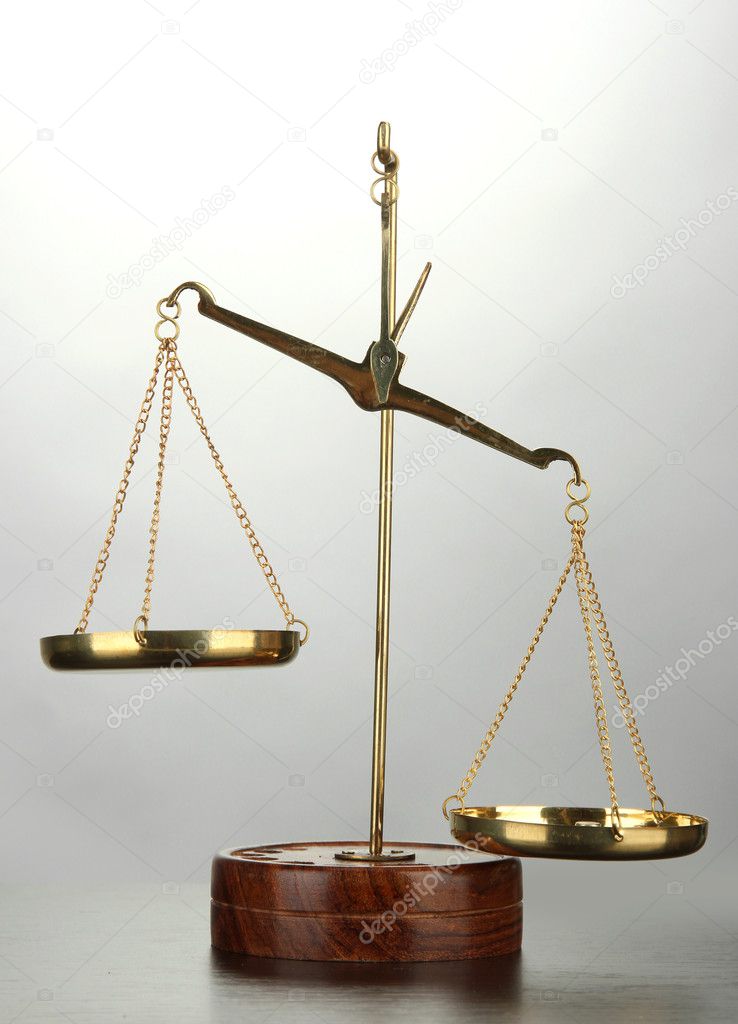 Gold scales of justice on grey background