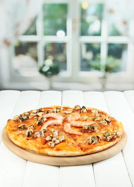 Deliziosa pizza con frutti di mare sul tavolo su sfondo luminoso — Foto Stock
