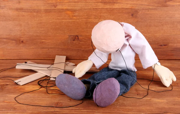 Houten marionet zittend op houten achtergrond — Stockfoto