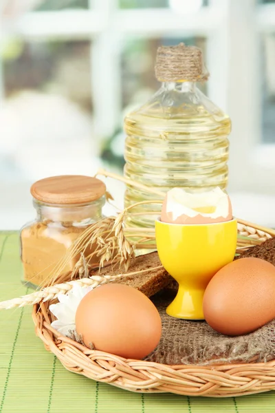 Gekookte eieren op rieten mat op lichte achtergrond — Stockfoto