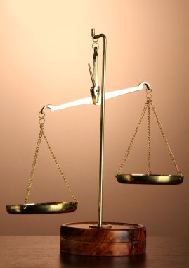 Adaletin kahverengi zemin üzerine altın terazisi