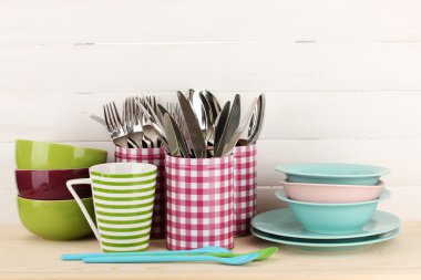 Cups, bowls nd other utensils in metal containers isolated on light background