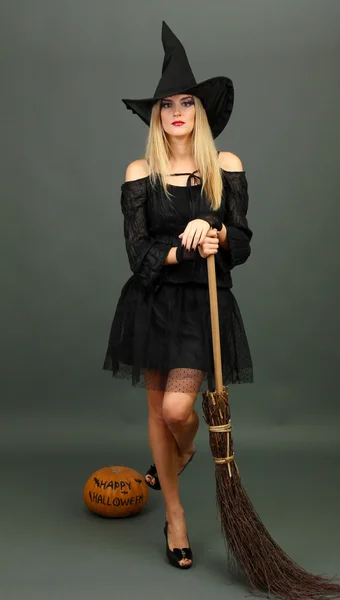 Halloween witch with broom on gray background — Stock Photo, Image