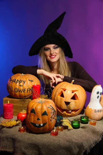 Halloween witch with pumpkins on color background — Stock Photo, Image