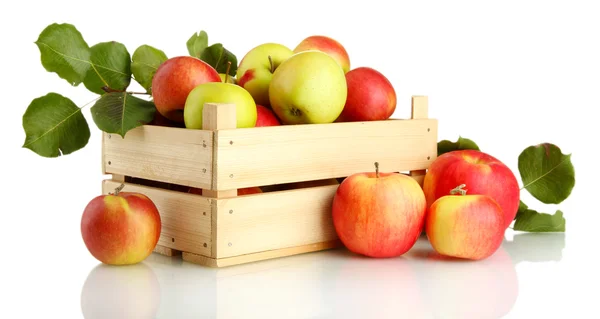 Šťavnatá jablka se zelenými listy v dřevěné bedně, izolované na bílém — Stock fotografie