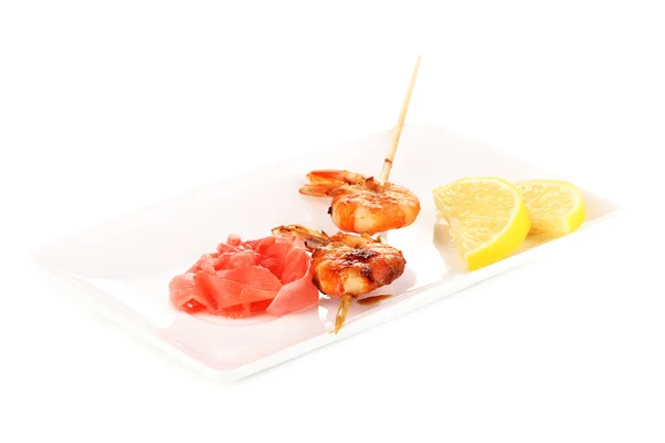 Shrimp skewers on plate with ginger and lemon isolated on white — Stock Photo, Image