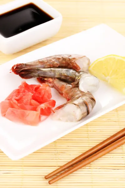 Espetos de camarão em prato com gengibre e limão — Fotografia de Stock
