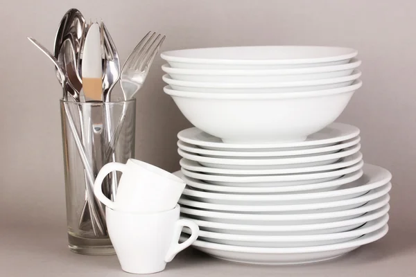Clean white dishes on grey background — Stock Photo, Image