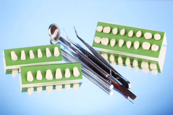 Set med dental verktyg med protes på blå bakgrund — Stockfoto