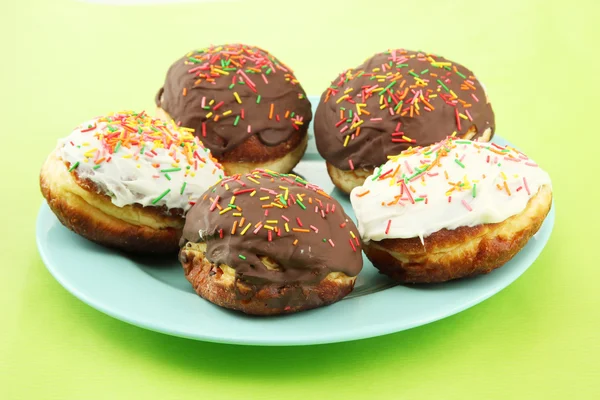 Donuts saborosos na placa de cor no fundo de cor — Fotografia de Stock