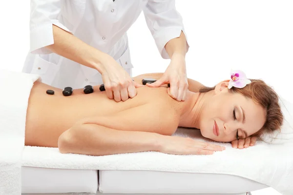 Bella donna in salone spa con pietre termali ottenere massaggio, isolato su bianco — Foto Stock