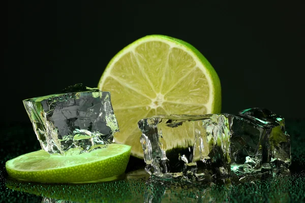 Ice cubes with lime on darck green background — Stock Photo, Image