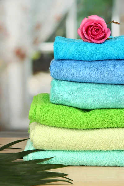 Stack of towels with fragrant flower on window background — Stock Photo, Image