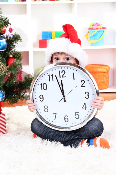 Child with clock in anticipation of New Year Stock Picture