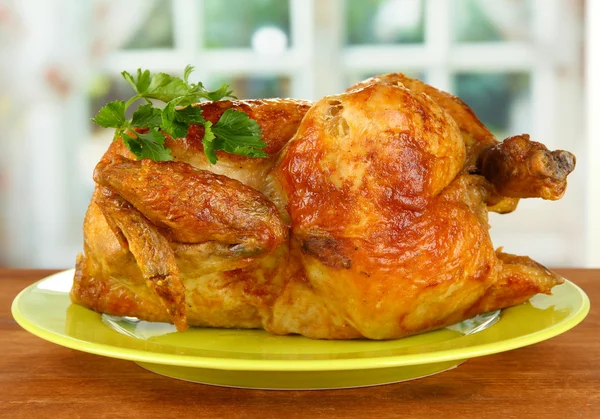 绿色盘子上木制背景特写上烤整鸡 — 图库照片