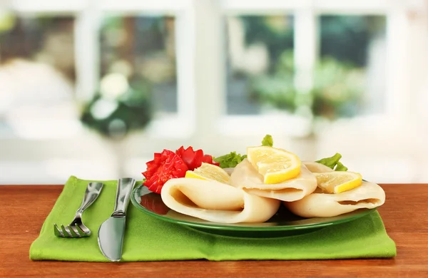 Calamares hervidos con verduras en el plato en la mesa de madera de cerca —  Fotos de Stock