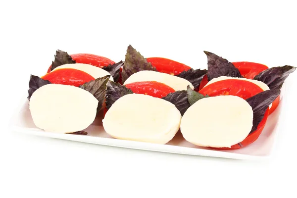 Gustosa mozzarella con pomodori su piatto isolato su bianco — Foto Stock