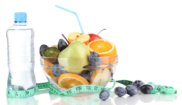 Cuenco de vidrio con fruta para dieta, cinta métrica y botella de agua aislada en blanco — Foto de Stock