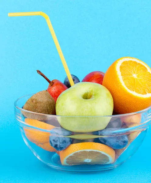 Ciotola di vetro con frutta per la dieta su sfondo blu — Foto Stock