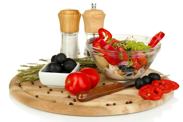 Ensalada griega fresca en tazón de vidrio rodeado de ingredientes para cocinar aislado en blanco —  Fotos de Stock