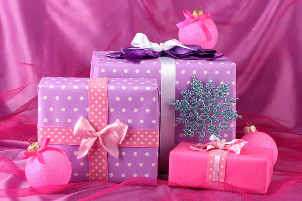 Bellissimi regali, palle di Natale e fiocco di neve su sfondo rosa — Foto Stock