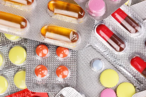 Cápsulas y pastillas empaquetadas en ampollas fondo de primer plano —  Fotos de Stock