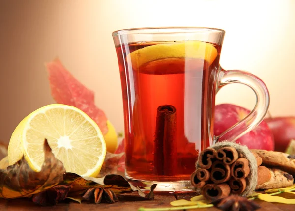 Чашка горячего чая и осенние листья, на коричневом фоне — стоковое фото