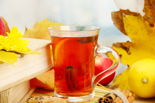 Taza de té caliente y hojas de otoño, sobre mesa de madera —  Fotos de Stock