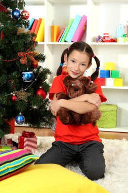 küçük bir kız tutmak Noel ağacının yanında oyuncak