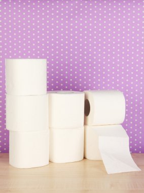 Rolls of toilet paper on purple with dots background