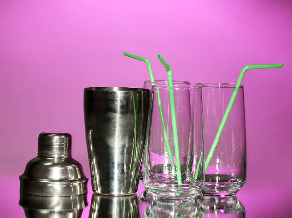 Cocktailshaker und Gläser auf farbigem Hintergrund — Stockfoto