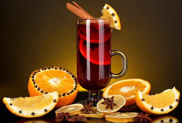 향료와 노란색 배경에 주위 오렌지와 유리에 향기로운 mulled 와인 — 스톡 사진
