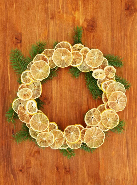 Ghirlanda natalizia di limoni secchi con abete, su fondo ligneo — Foto Stock