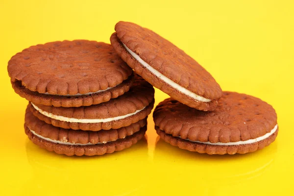 Chocolate cookies with creamy layer on yellow background — Stock Photo, Image