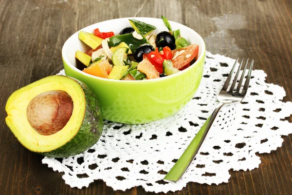 Tasty avocado salad in bowl on wooden table close-up — Stock Photo, Image