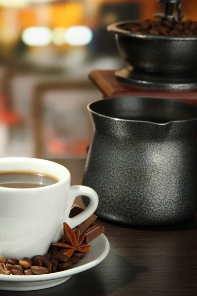 Cup of coffee, grinder, turk and coffee beans in cafe — Stock Photo, Image