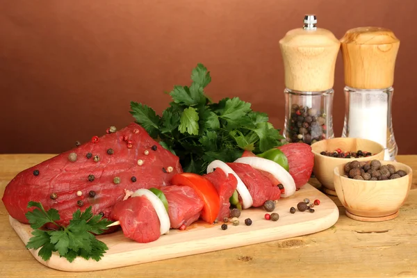 Carne de res cruda marinado con hierbas y especias sobre mesa de madera sobre fondo marrón —  Fotos de Stock