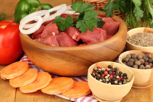 Ruwe rundvlees vlees gemarineerd met kruiden en specerijen op houten tafel op bruine achtergrond — Stockfoto