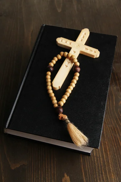 Bibel, Rosenkranz und Kreuz auf Holztisch in Großaufnahme — Stockfoto