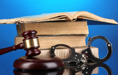 Tokmak, kelepçe ve kitap üzerinde mavi arka plan hakkında kanun