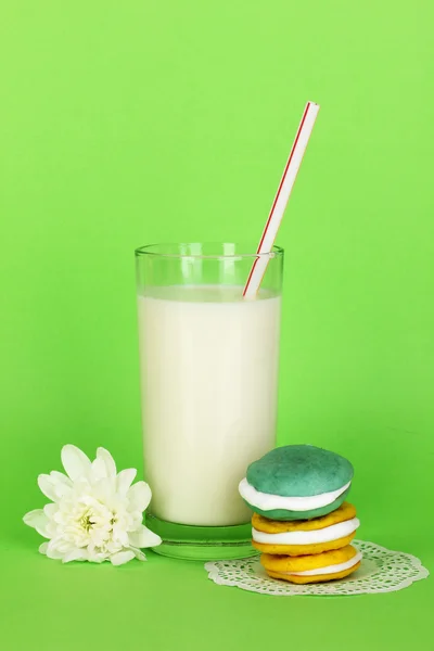 Verre de lait frais neuf avec des gâteaux sur fond vert — Photo