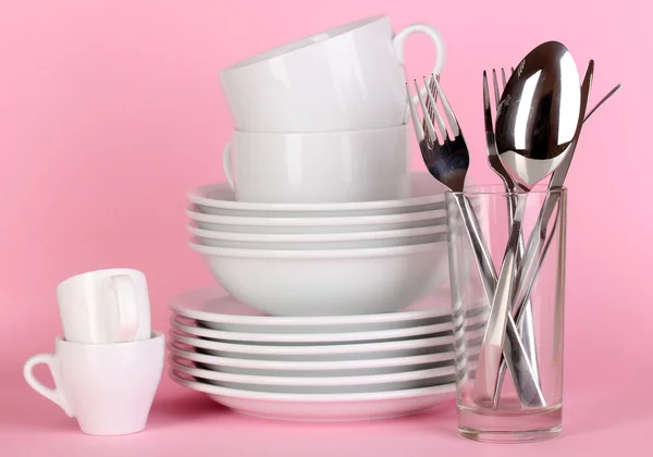 Čisté bílé nádobí na růžovém pozadí — Stock fotografie