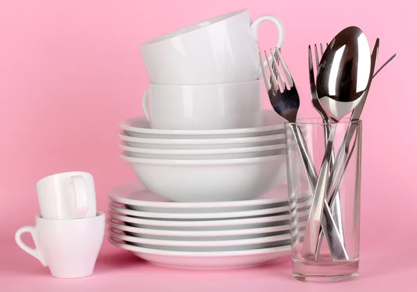 Clean white dishes on pink background — Stock Photo, Image