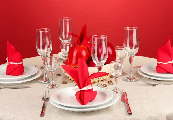 Table setting in red tones on color background — Stock Photo, Image