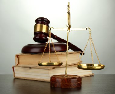 Altın pul, adalet, tokmak ve gri arka plan üzerine kitaplar